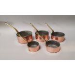 Set of five early 20th C. copper and brass sauce pots.