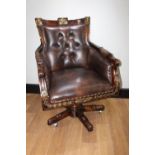 Gilded mahogany leather upholstered swivel armchair.