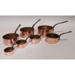 Set of seven copper and metal saucepans.
