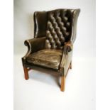 Leather deep buttoned upholstered wingback armchair.