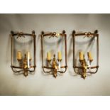 Set of three brass wall lights.