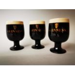 Three Guinness advertising egg cups.