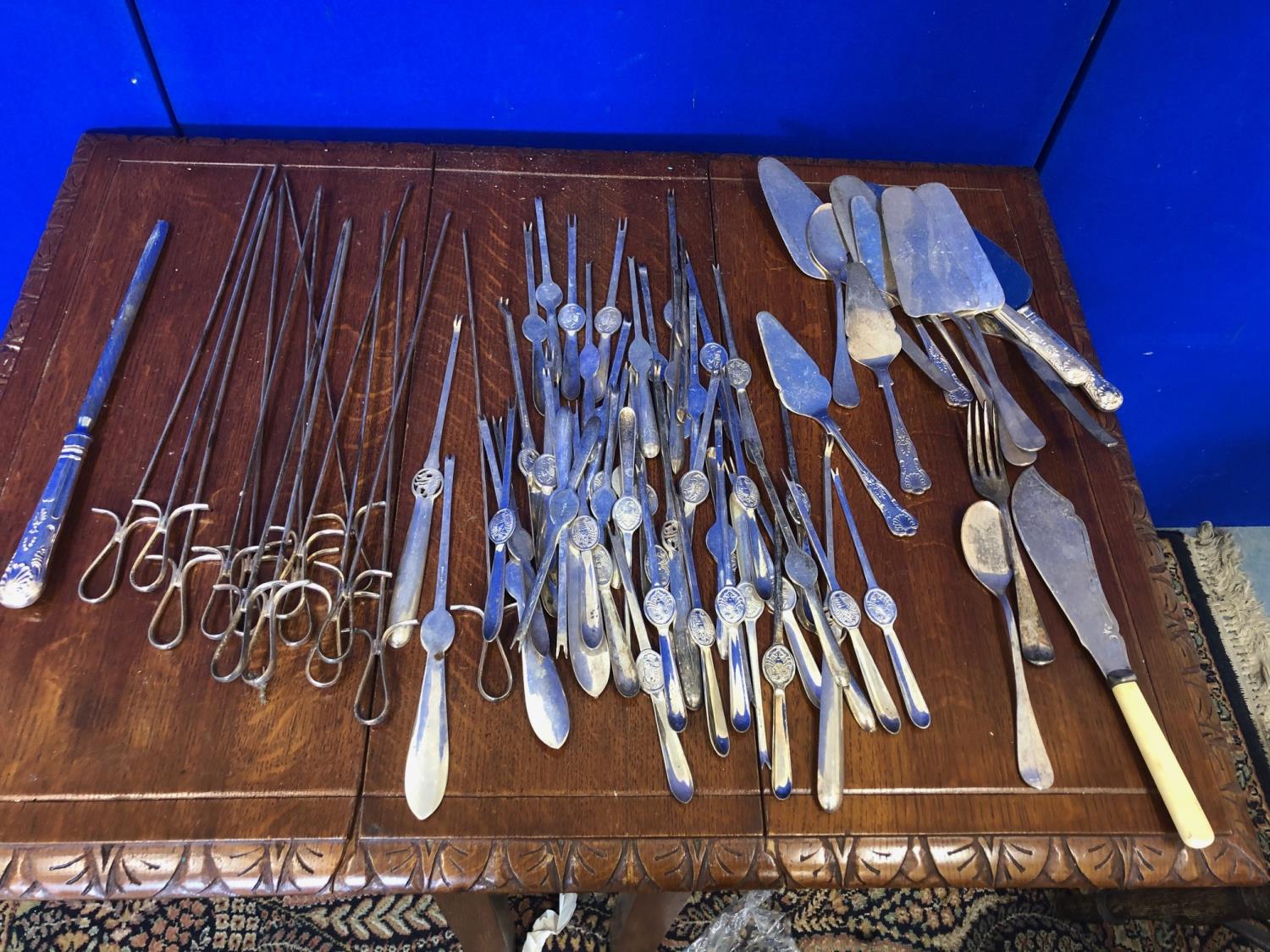 Large collection of cutlery including meat skewers and crab cutlery.