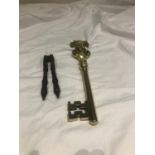 Ceremonial brass key on hanger and an antique nut cracker.
