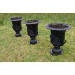 Set of three cast iron garden urns.