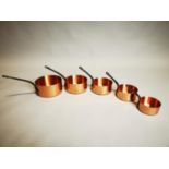 Set of graduated copper saucepans.