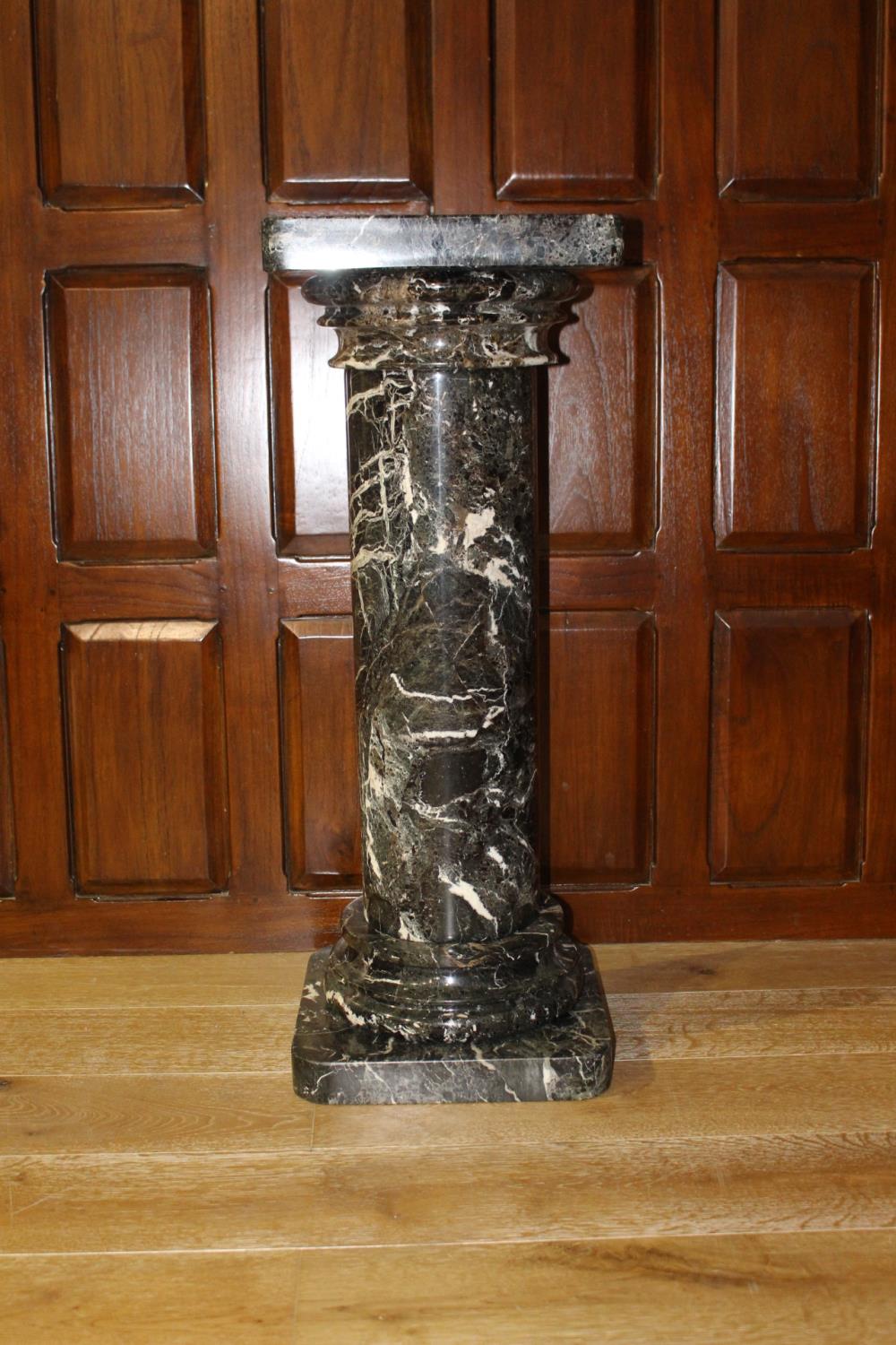 Marble pedestal with Corinthian top.