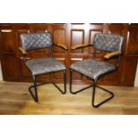 Pair of leather upholstered metal and wood armchairs.