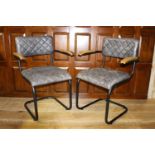 Pair of leather upholstered metal and wood armchairs.