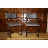 Pair of leather upholstered metal and wood armchairs.