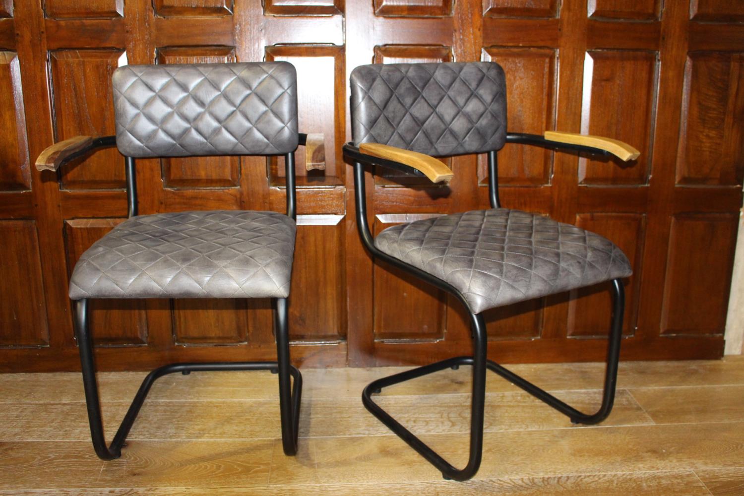 Pair of leather upholstered metal and wood armchairs.