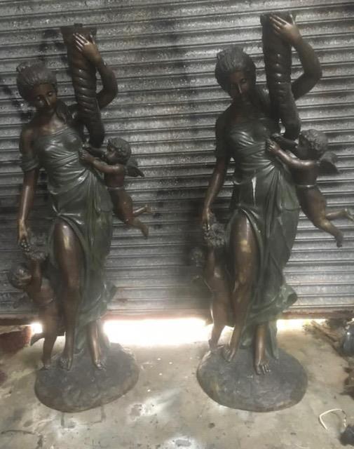Pair of cast bronze torchieres depicting ladies.