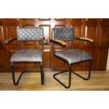 Pair of leather upholstered metal and wood armchairs.