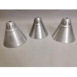 Three polished metal conical light shades