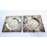 Pair of square white metal ashtrays with symbols in each corner. Measurement: 4 3/8” square. Weight: