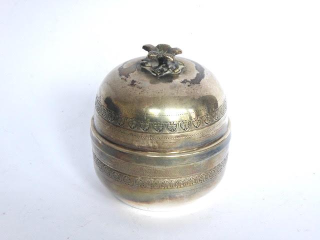 Circular white metal trinket box and cover with flower finial. Diameter: 2 ¾”