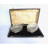 Pair of pierced oval silver plated butter dishes with glass liners, in original case, and a set of