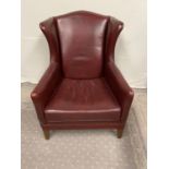 Leather upholstered wing backed armchair.