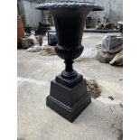 Pair of cast iron urns on bases