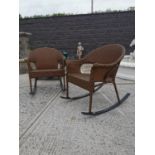 Pair of rattan rocking chairs on metal base.