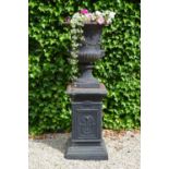 Decorative cast iron urn on pedestal