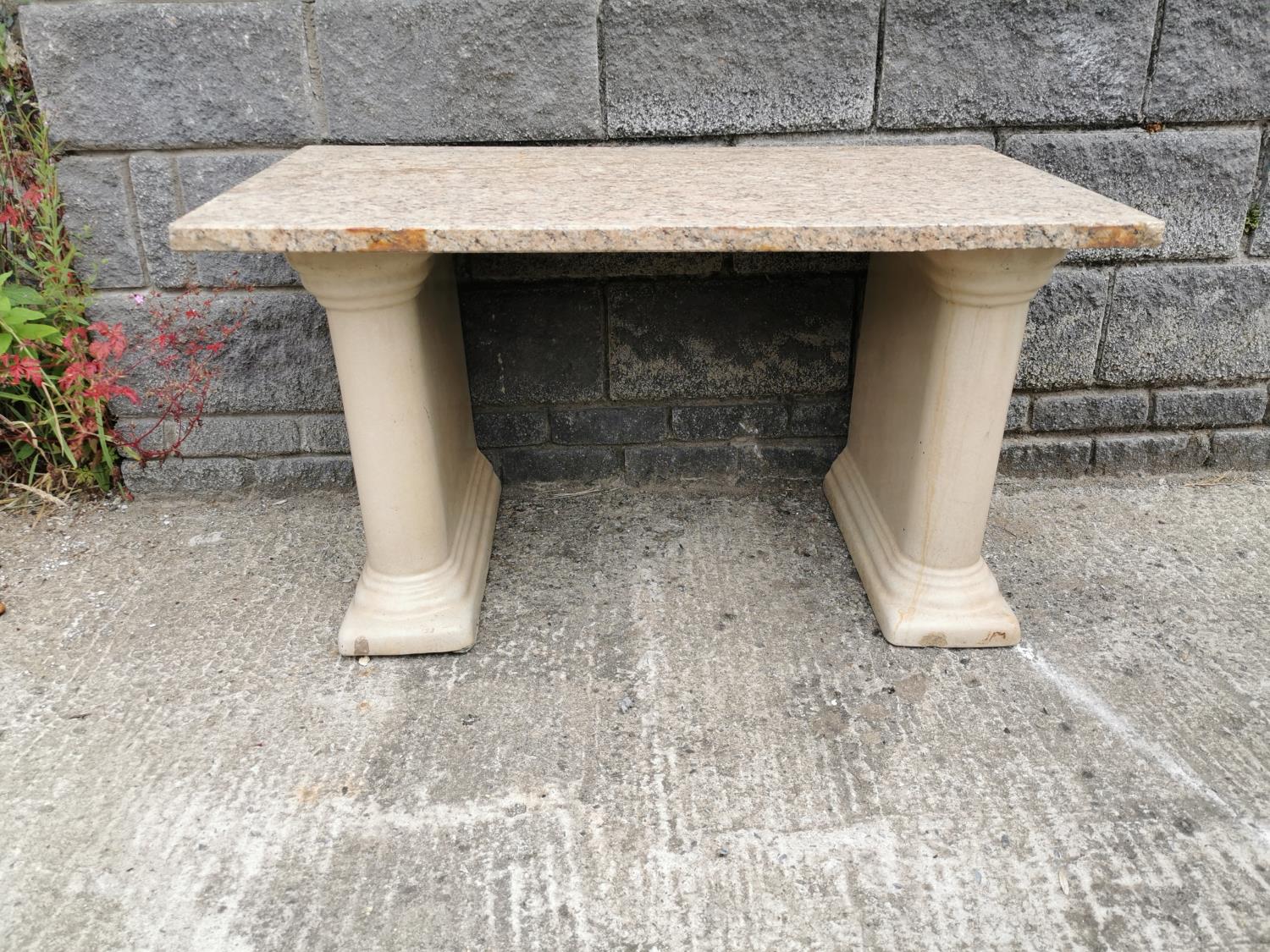 Garden table with stoneware pedestals and marble top.