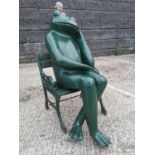Cast iron frog resting on a chair .