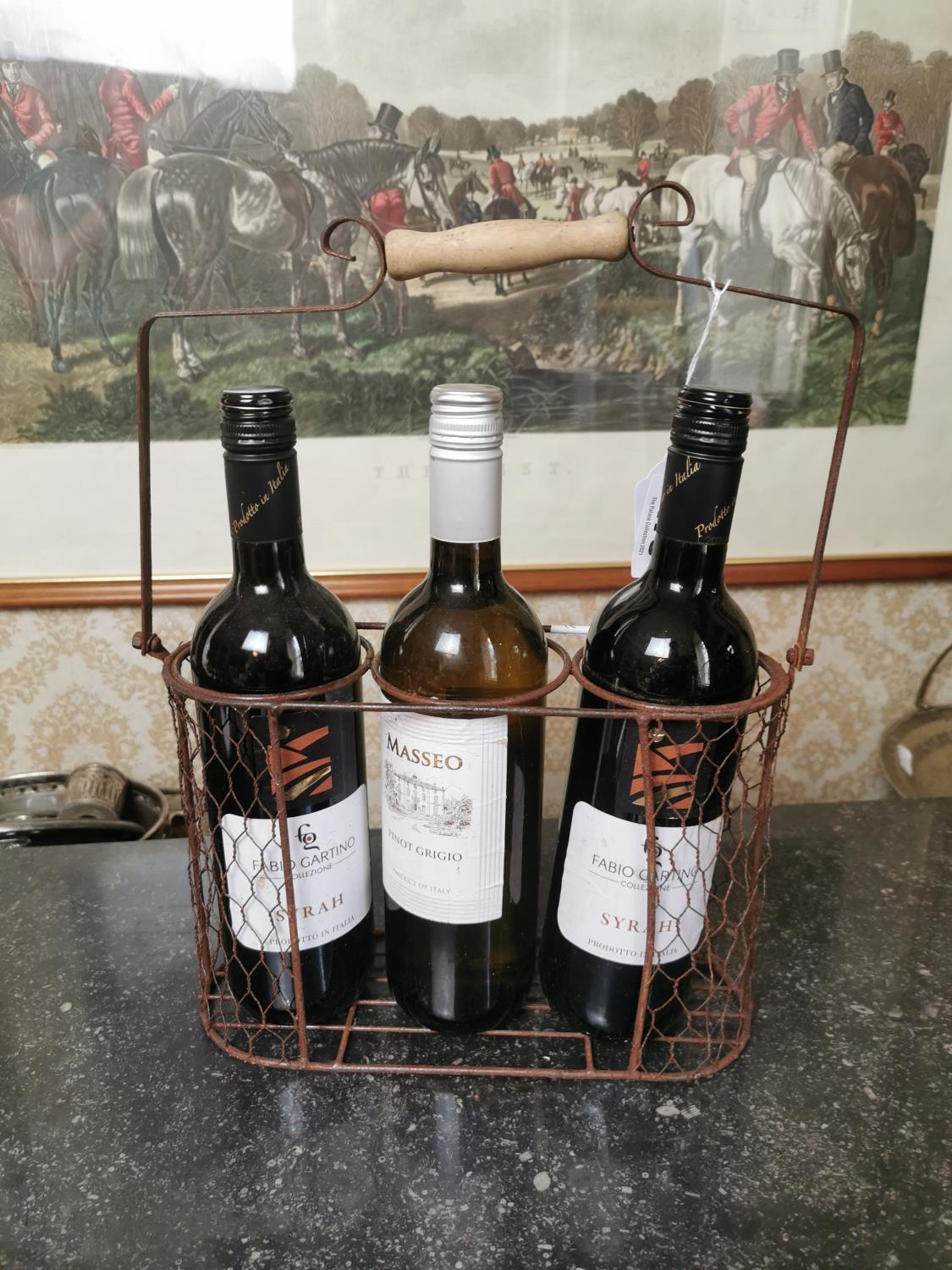 Three bottles of wine in metal holder