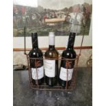 Three bottles of wine in metal holder