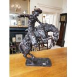 Painted metal model of a rodeo rider and horse.