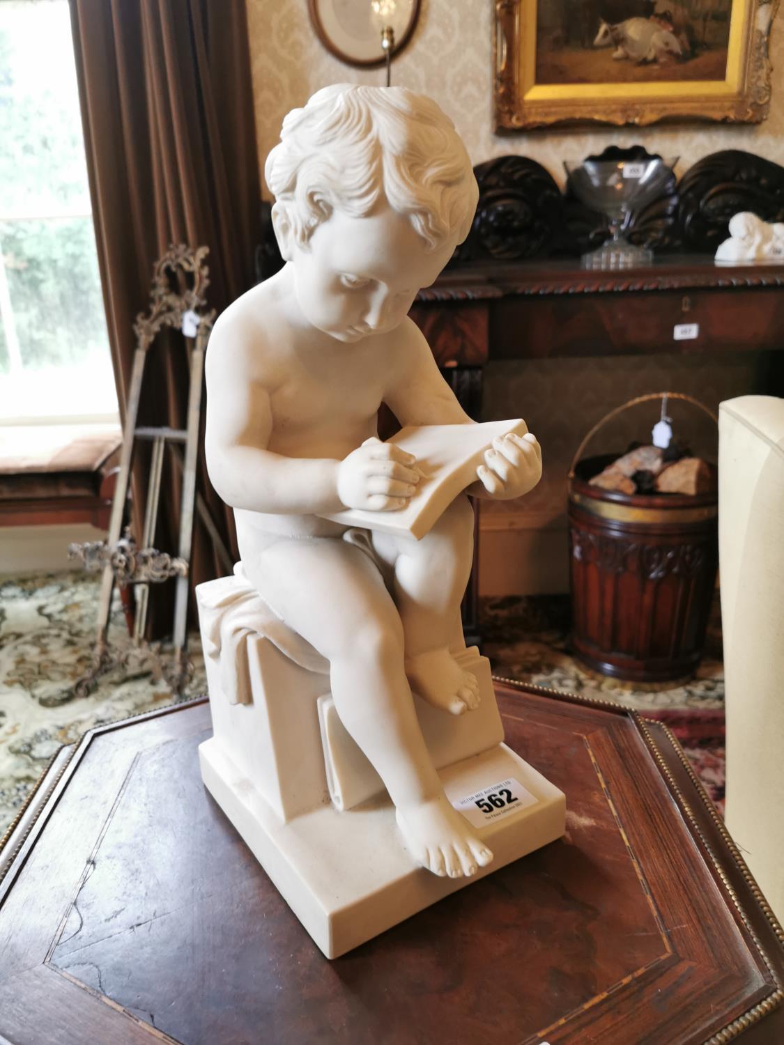 Resin model of a Cherub writing.