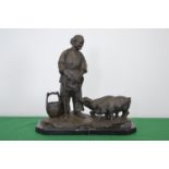 Bronze figurine of a woman feeding pigs