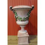 Pair of decorate ceramic urns on pedestal.