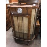 WALNUT BOW FRONT GLAZED CABINET WITH INSET CLOCK