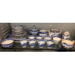 SHELF OF BLUE AND WHITE WILLOW PATTERN TEACUPS AND SAUCERS AND A CHINESE BALUSTER VASE AND COVER