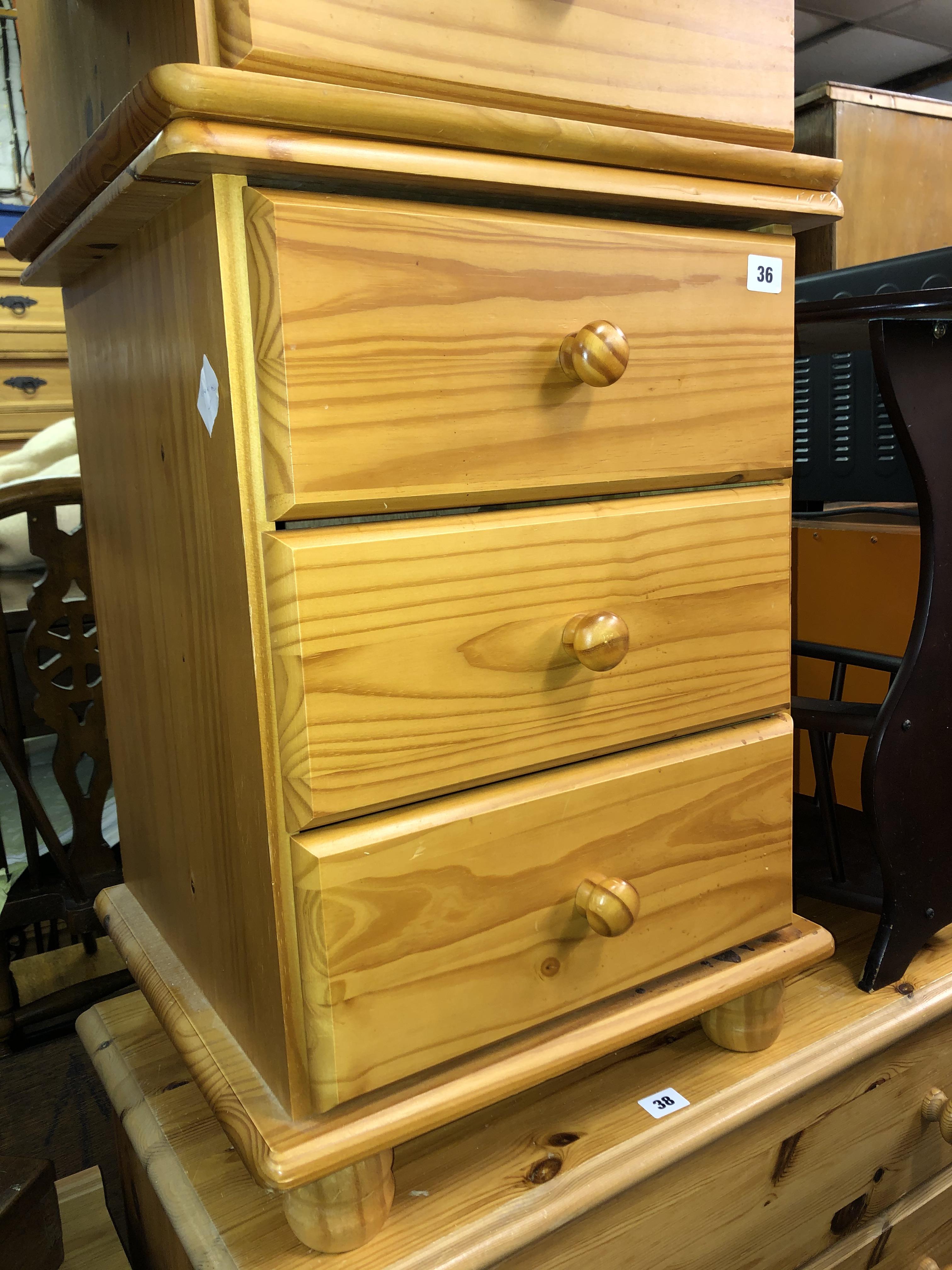 PAIR OF PINE THREE DRAWER BEDSIDE CHESTS AND AN OVAL MAGAZINE TABLE