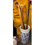 BLUE AND WHITE CYLINDRICAL POTTERY STICK STAND AND A SELECTION OF WALKING CANES