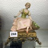 ITALIAN POTTERY FIGURE GROUP OF GIRL WITH FLOWER BASKET ON ORNATE GILT METAL BASE 19CM H APPROX