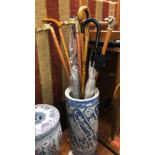 CHINESE STYLE BLUE AND WHITE CYLINDRICAL CANE STANDS WITH UMBRELLAS AND WALKING STICKS