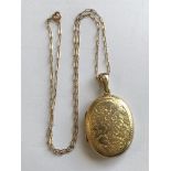 9CT GOLD FANCY LINK CHAIN WITH AN UNMARKED YELLOW METAL ENGRAVED OVAL LOCKET 10.