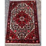 20TH CENTURY WOOL PILE RED GROUND RUG 148 X 97CM APPROX