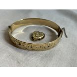 ROLLED GOLD HEART SHAPED LOCKET AND A 9CT METAL CORE ENGRAVED BANGLE