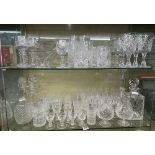 TWO SHELVES OF GOOD CUT GLASSWARE INCLUDING BRANDY GOBLETS, DECANTERS, ETC.
