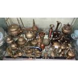 GOOD SHELF OF BRASS WARE MADE UP OF VARIOUS SIZED TEAPOTS ON STANDS, SPILL VASES, BELLS,