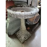 STONE BIRDBATH ON A FLUTED ACANTHUS AND SCROLLED SQUARE COLUMN,