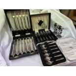 EPNS CASED TEA SPOON AND CUTLERY SETS AND A PAIR OF MINIATURE CHERUB FIGURAL CANDLE STICKS