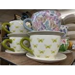 FOUR OVERSIZED CERAMIC BUTTERFLY PRINTED TEACUP AND SAUCER PLANTERS (THREE GREEN AND ONE MULTI