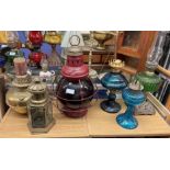 PERKINS 8" RED GLOBE MARITIME LANTERN AND A SELECTION OF COLOURED GLASS AND BRASS OIL LAMPS