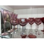 TWO SETS OF SIX PINK TINTED WINE GLASSES AND FOUR TALL FLUTES