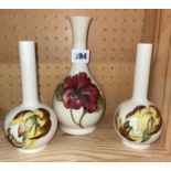 PAIR OF MOORCROFT CREAM BUD/SPILL VASES DECORATED WITH LEAVES AND ONE HIBISCUS VASE A/F